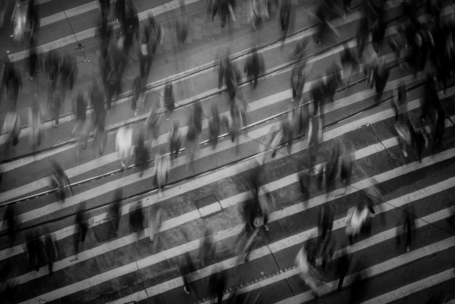 Blurred image of a crowd of people walking across the street