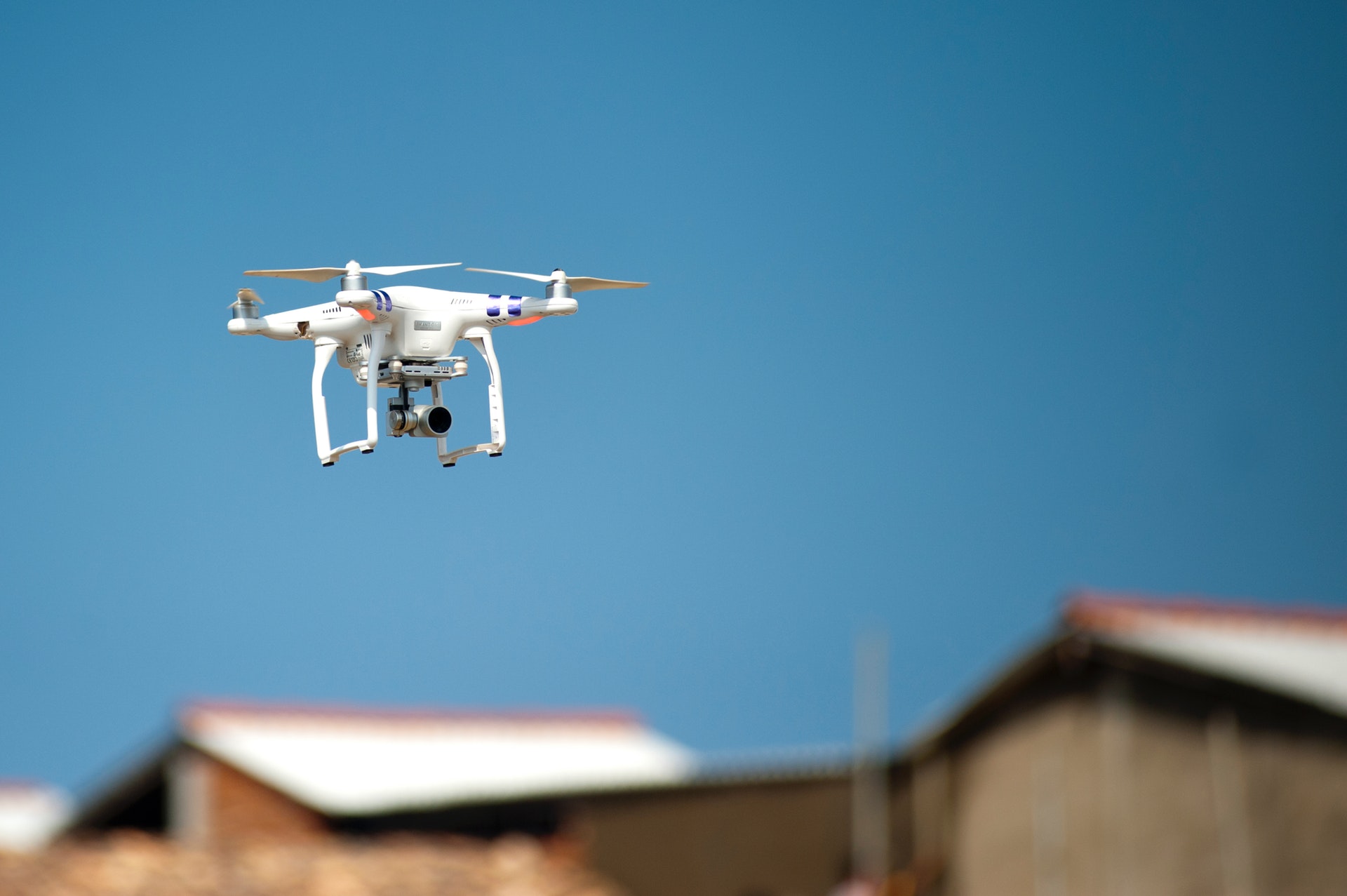 Flying drone taking pictures and recording video of houses