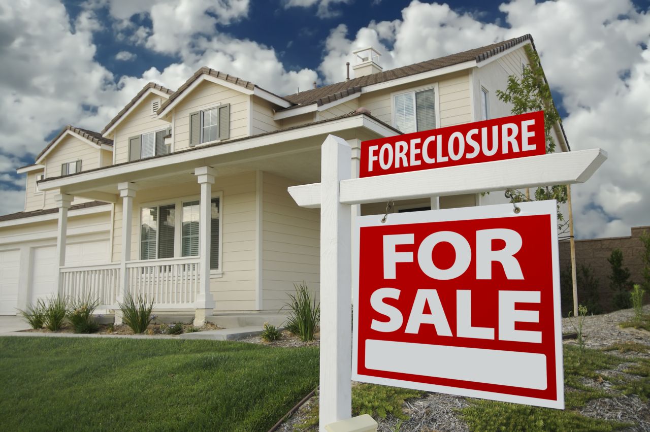 Foreclosure for sale sign on front lawn of house
