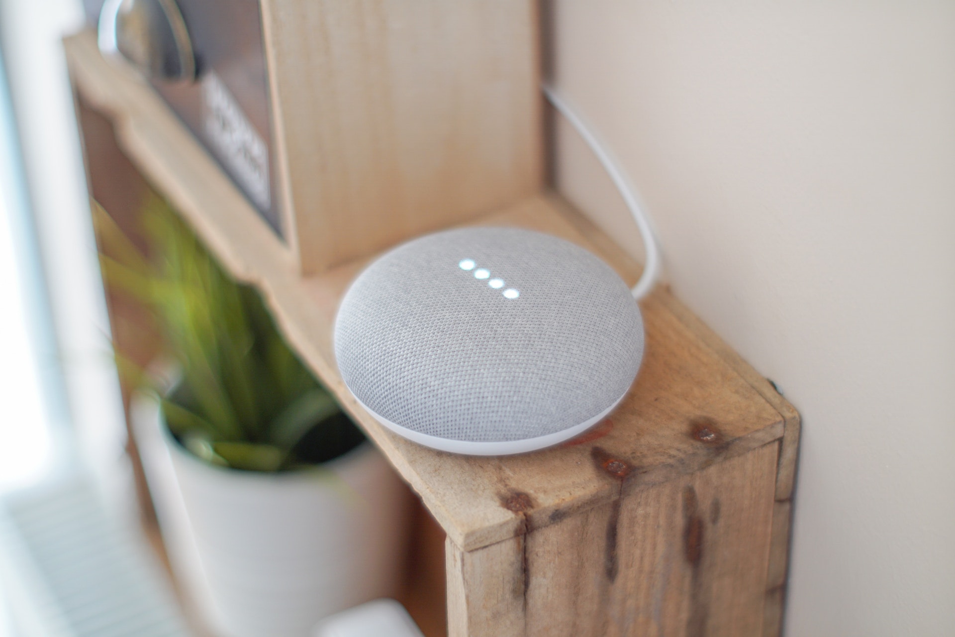 Grey google home mini on shelf