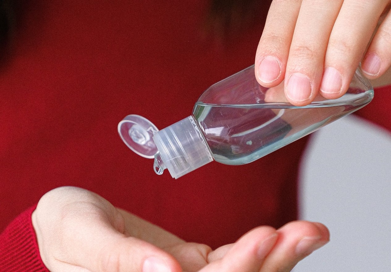 real estate agent putting on hand sanitizer