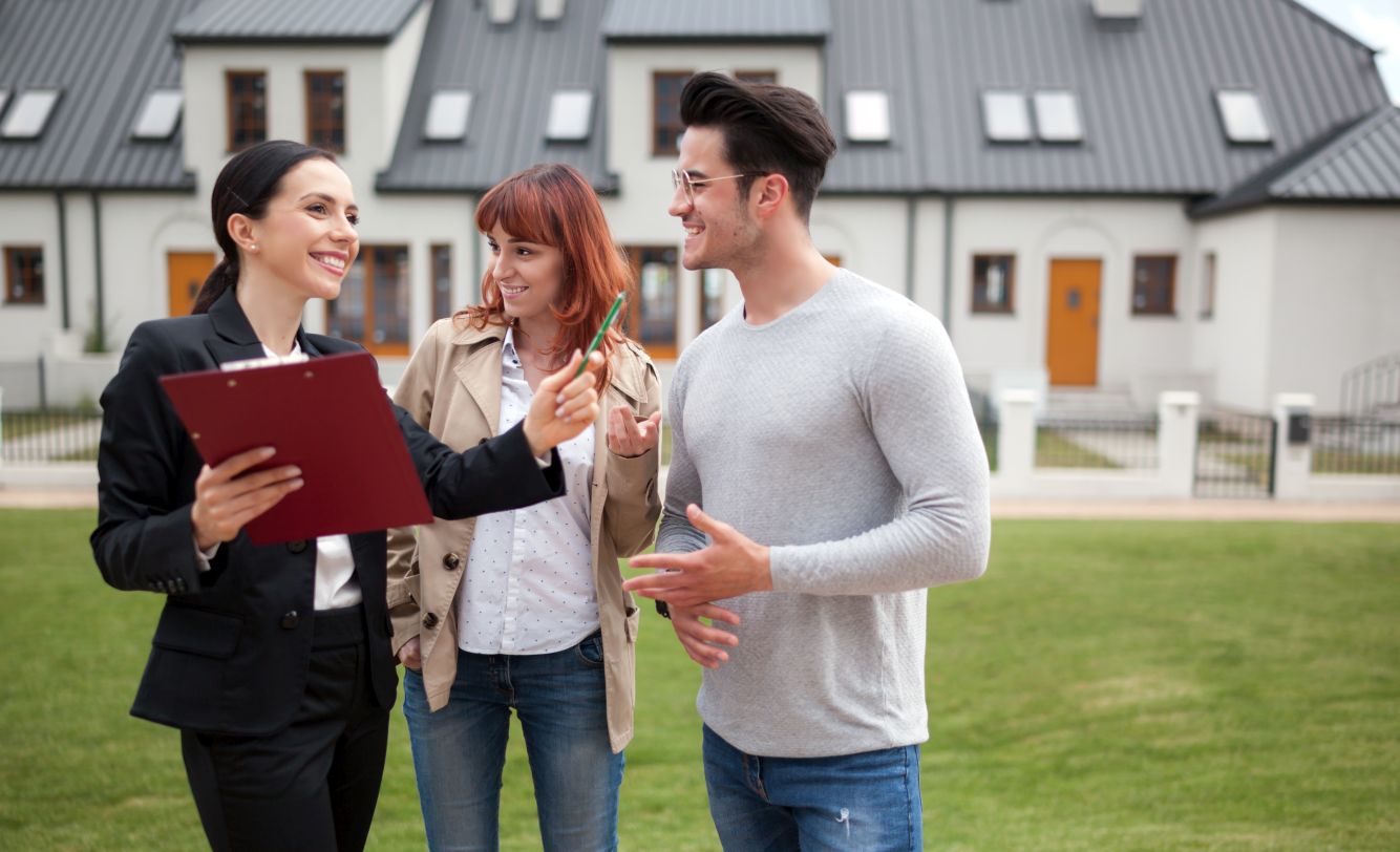 Real estate agent showing potential property to young couple