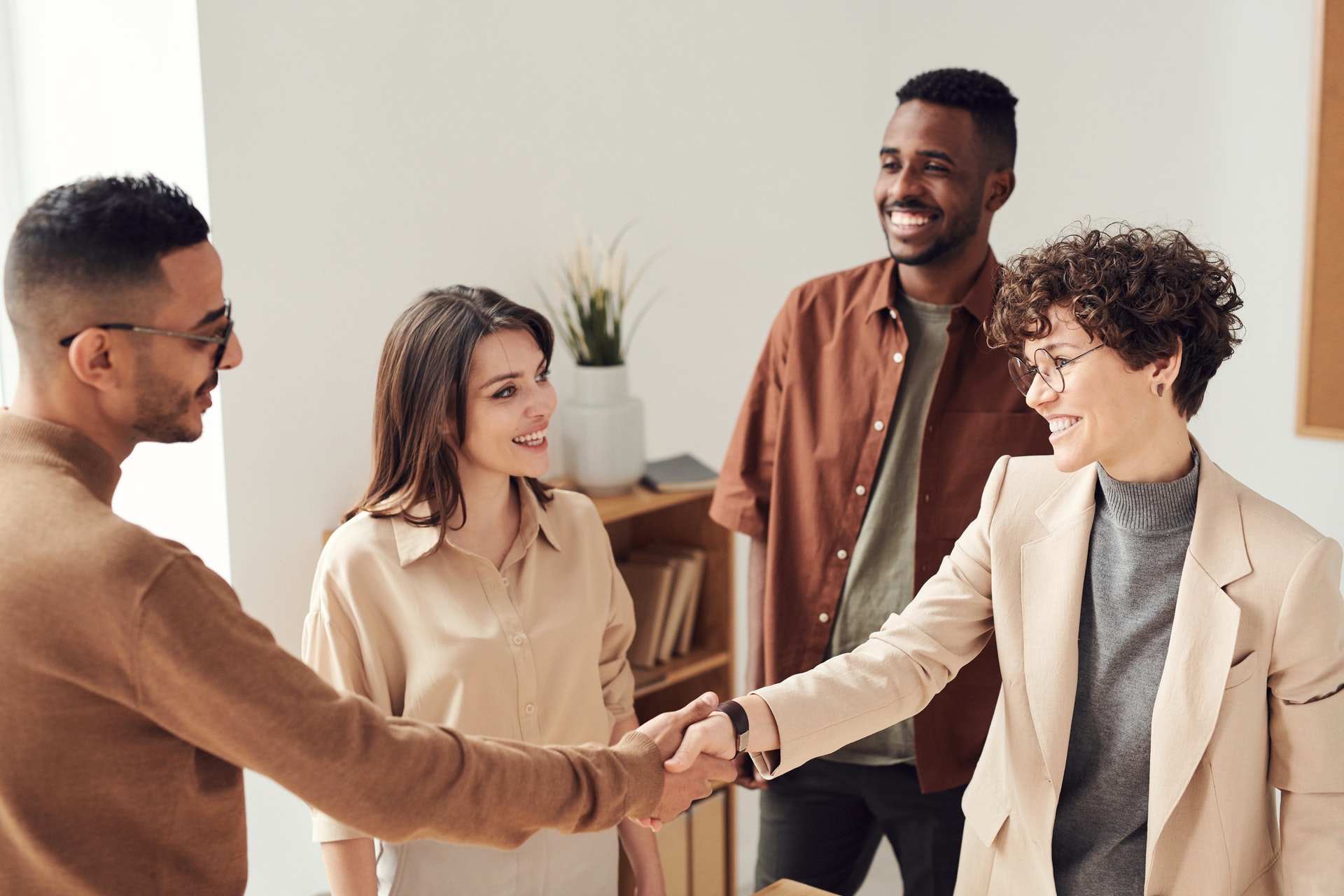 Real estate agents shaking hands of clients and smiling