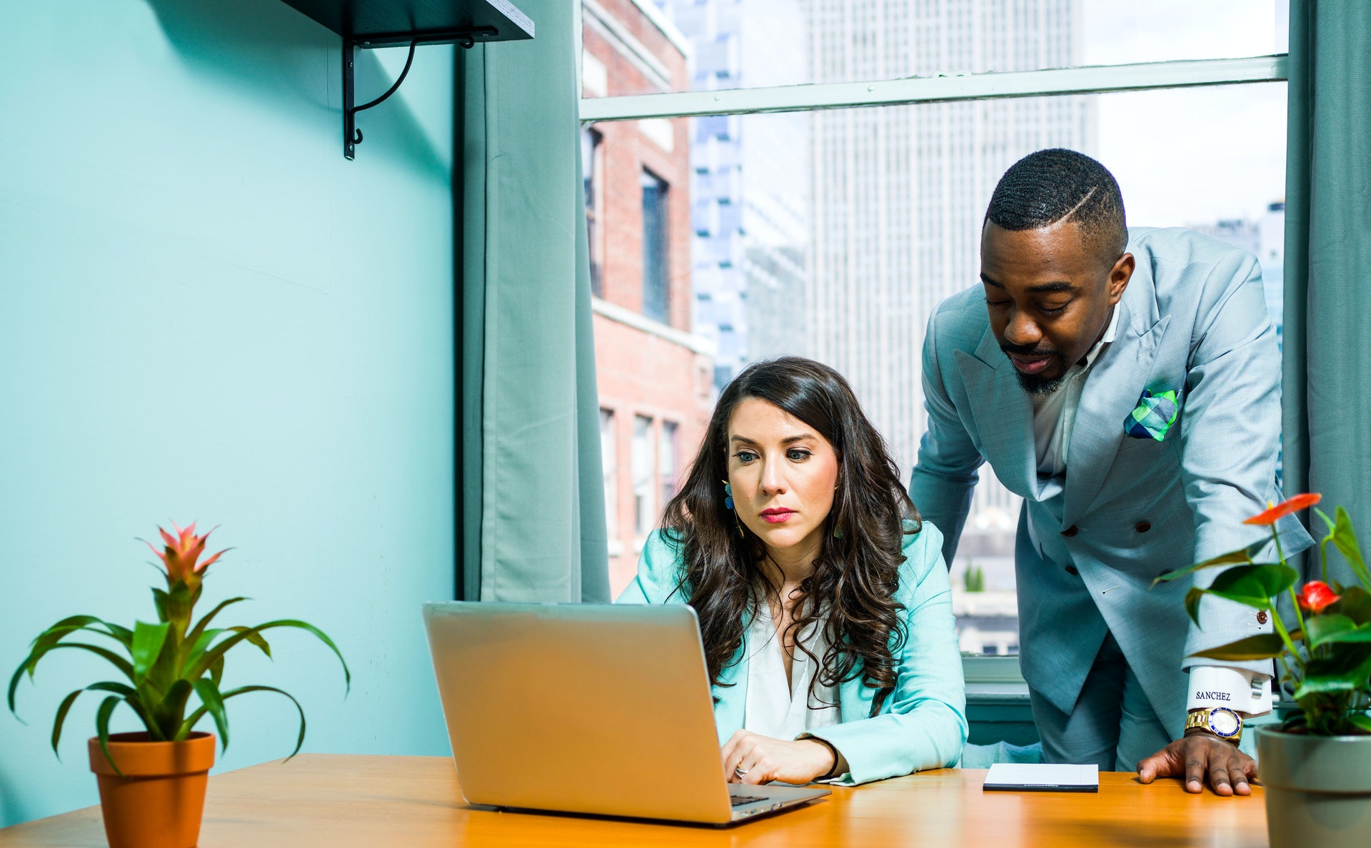 Real estate mentor showing mentee something on laptop