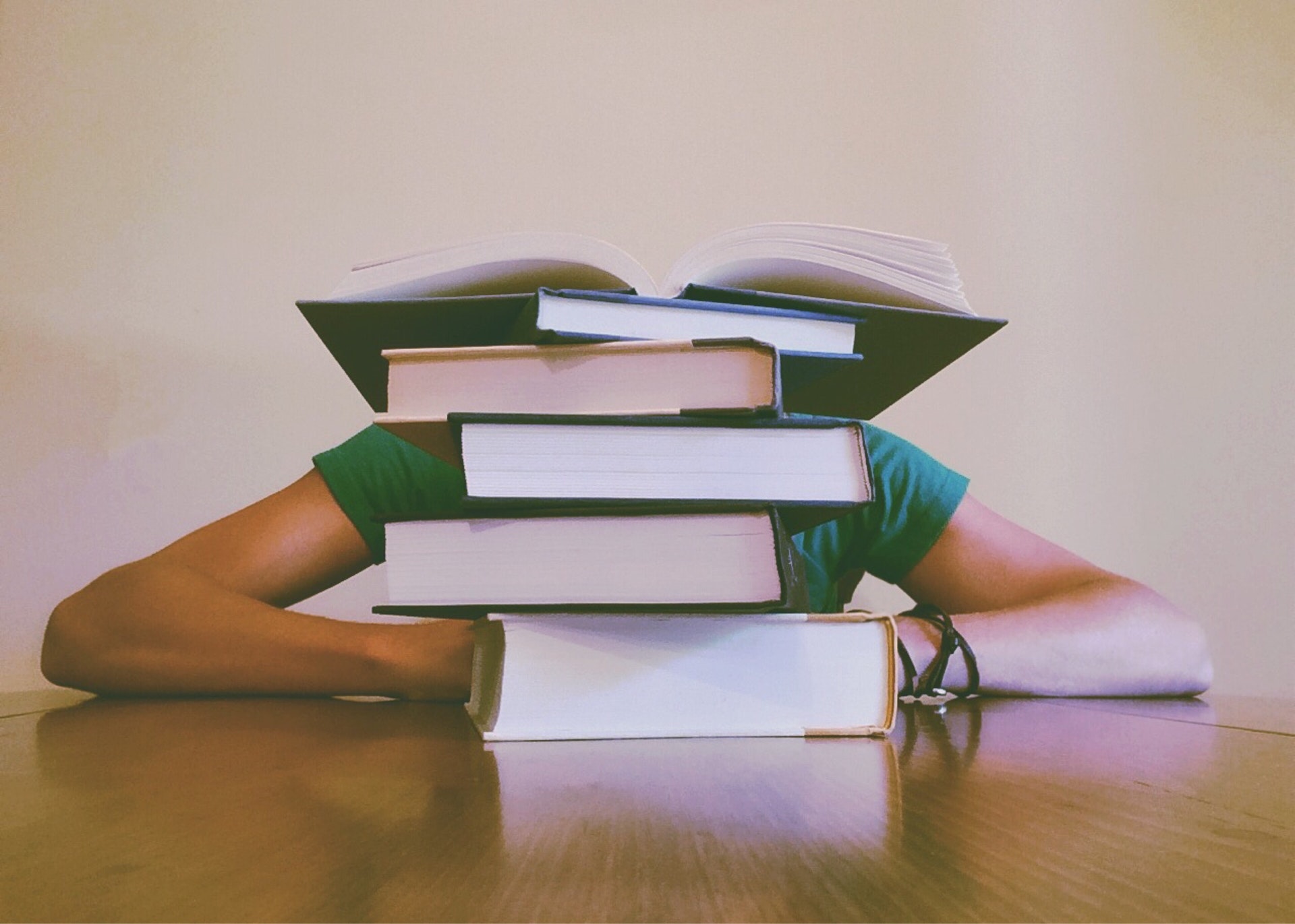 Real estate school student sitting in front of stack of textbooks