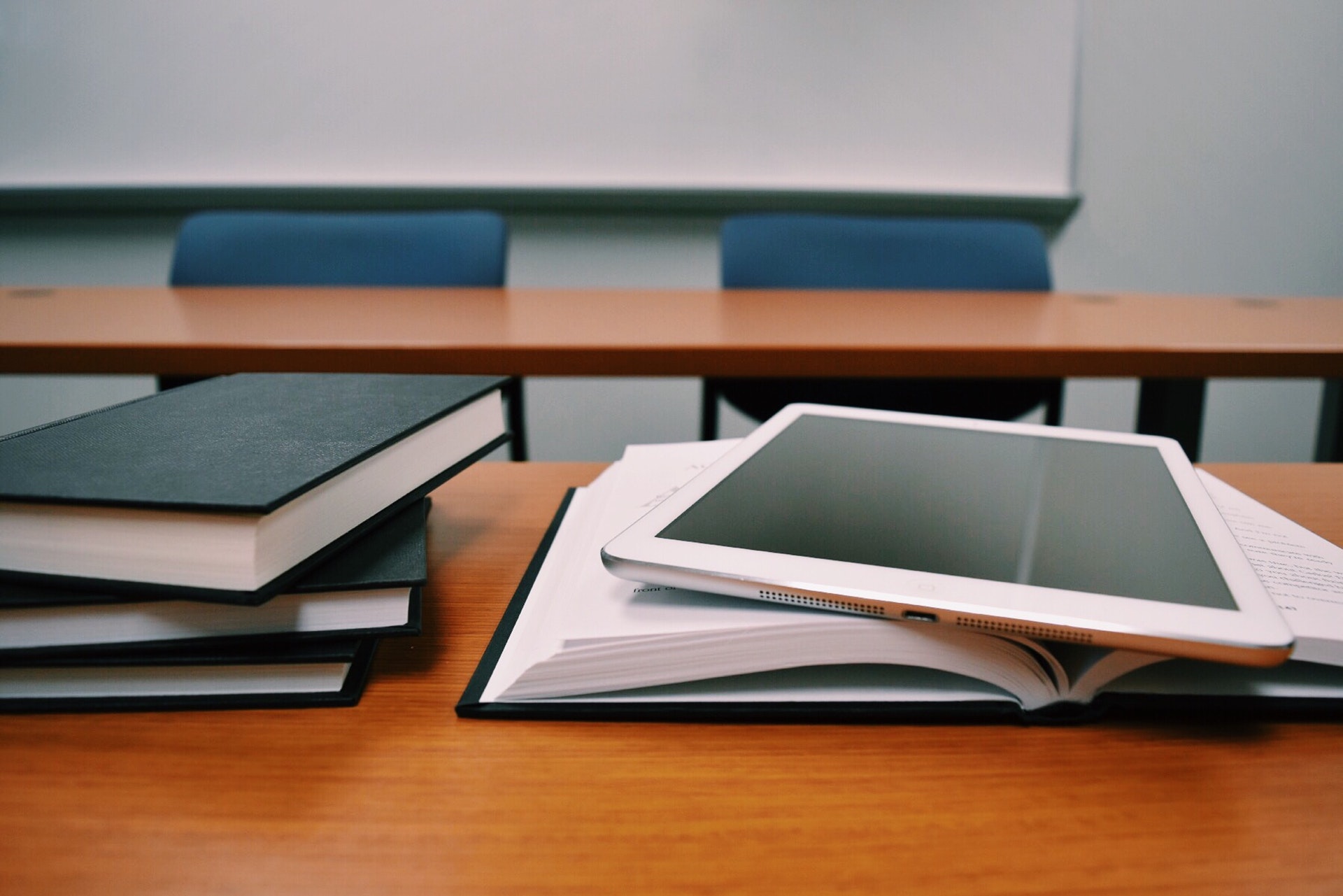 Real estate textbooks and ipad on desk inside of classroom