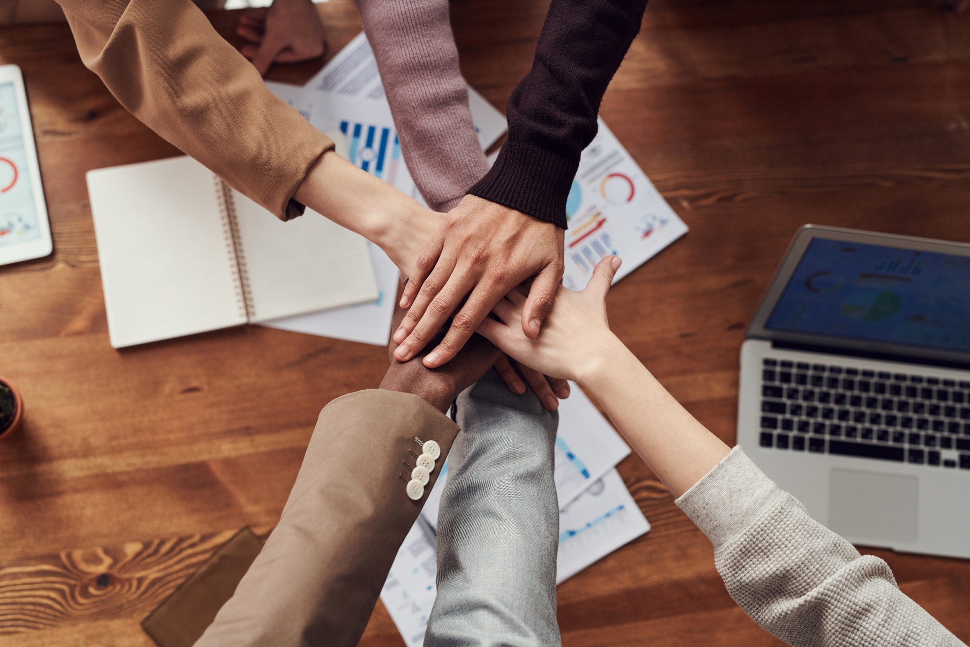 Realty company members breaking hand over hand after a meeting